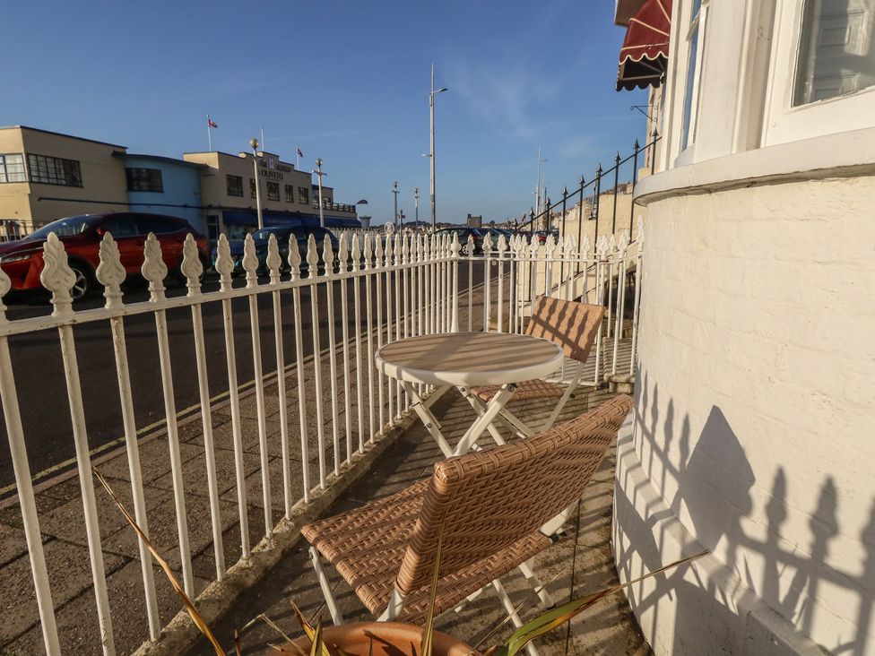 An outdoor seating area with a table and chairs at Number 3 by the Sea in Weymouth