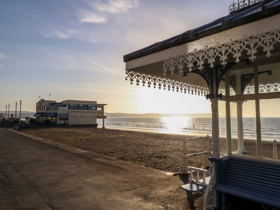 A beach scene with a building and a bench at Number 3 by the Sea Weymouth