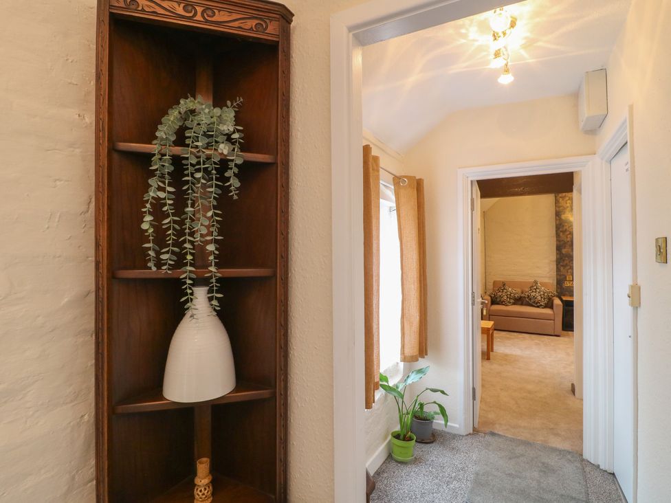 A hallway with a shelf and plant at Stay @ Mantra in Stoke Albany