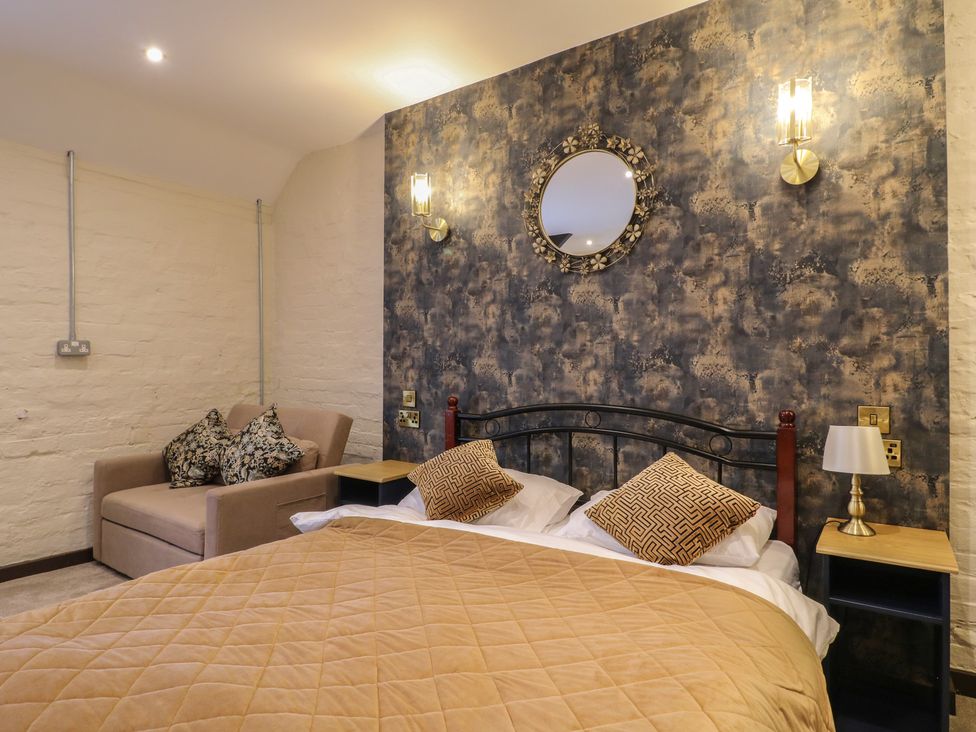 A bedroom with a bed and sofa at Stay @ Mantra Stoke Albany