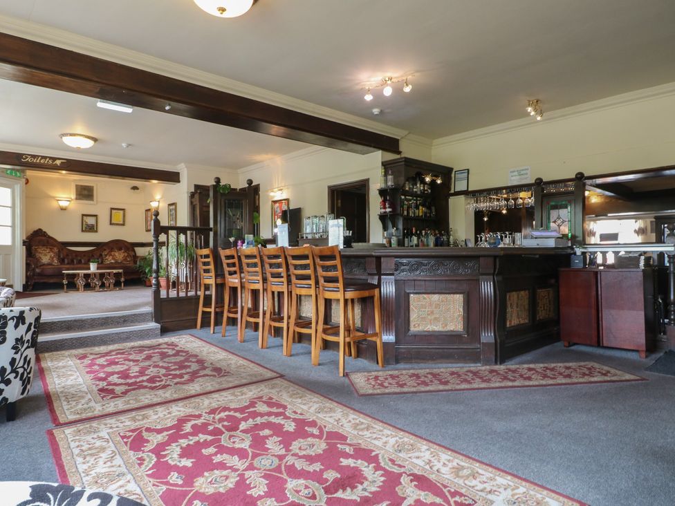 A bar area with stools and a seating area at Stay @ Mantra Stoke Albany