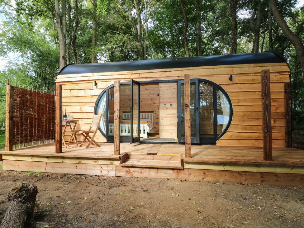A wooden cabin with a deck and outdoor furniture at Mallard Lodge in Marlow