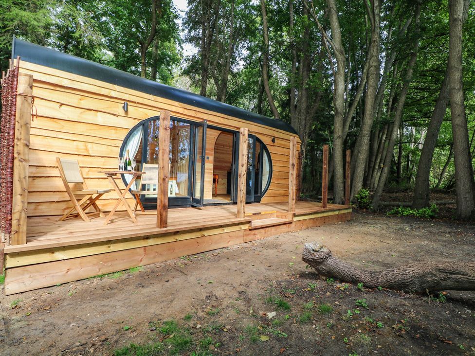 A wooden cabin with sliding glass doors and outdoor deck at Mallard Lodge in Marlow