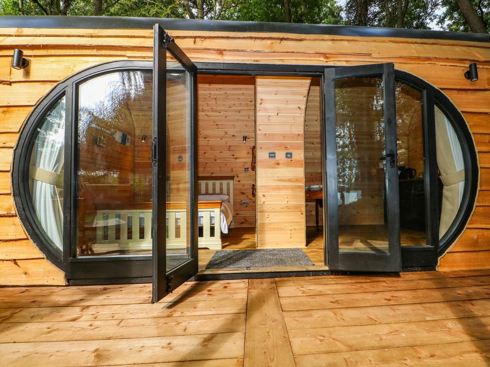 A bedroom with a bed and table at Mallard Lodge in Marlow