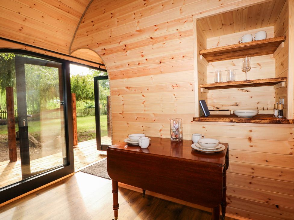 A dining area with wooden furniture at Mallard Lodge in Marlow