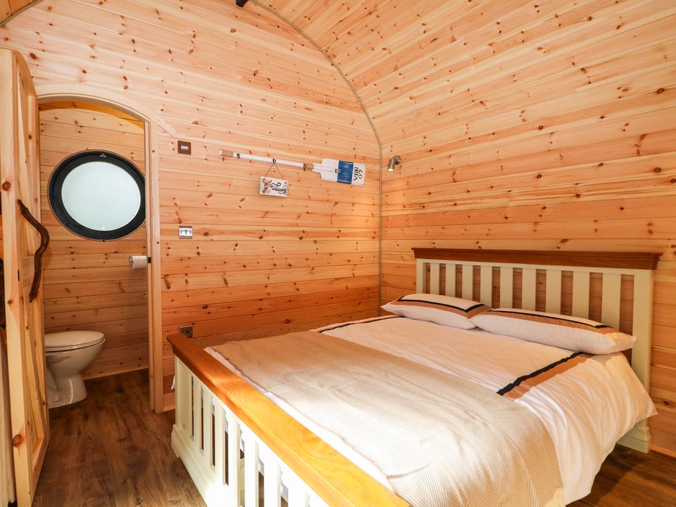 A bedroom with a bed and a toilet at Mallard Lodge in Marlow