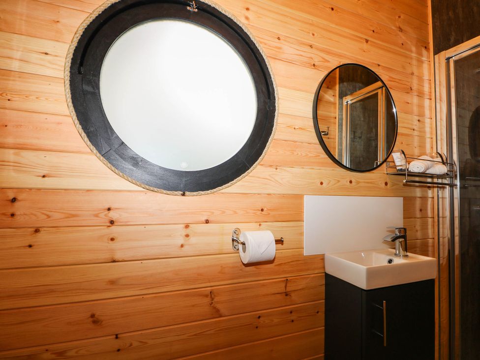 A bathroom with a sink and mirrors at Mallard Lodge in Marlow