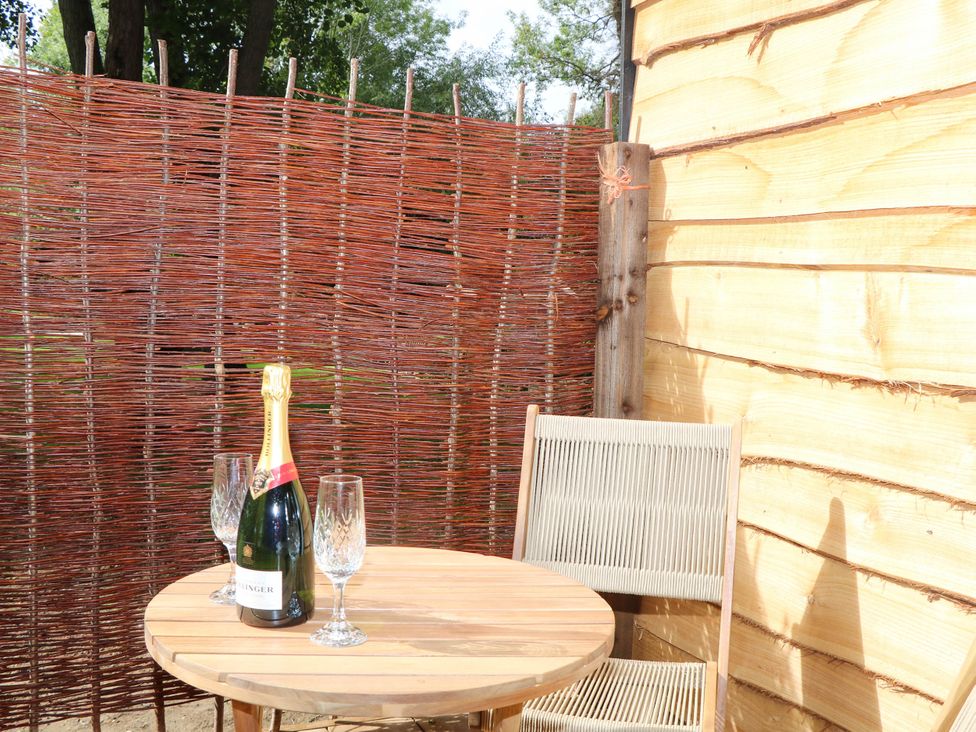 An outdoor area with a table, champagne bottle, and glasses at Mallard Lodge in Marlow
