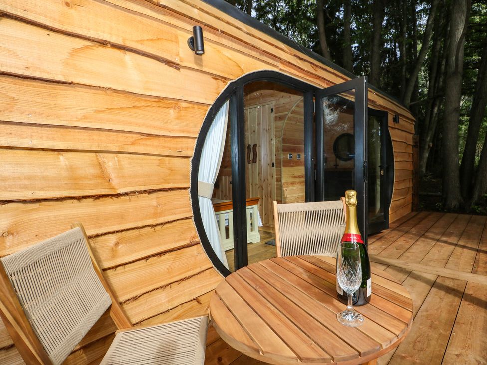 An outdoor seating area with a wooden cabin and table at Mallard Lodge in Marlow