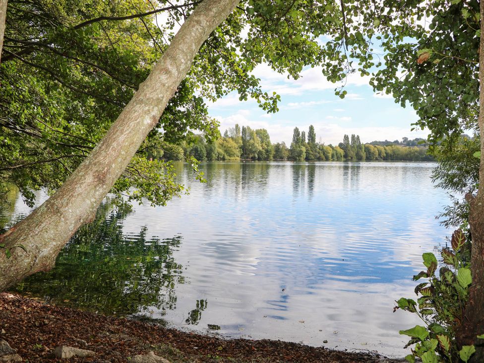 A tranquil lake surrounded by trees at Mallard Lodge in Marlow