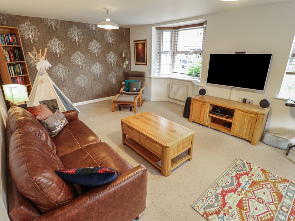 A living room with a sofa and television at 26 Otho Way