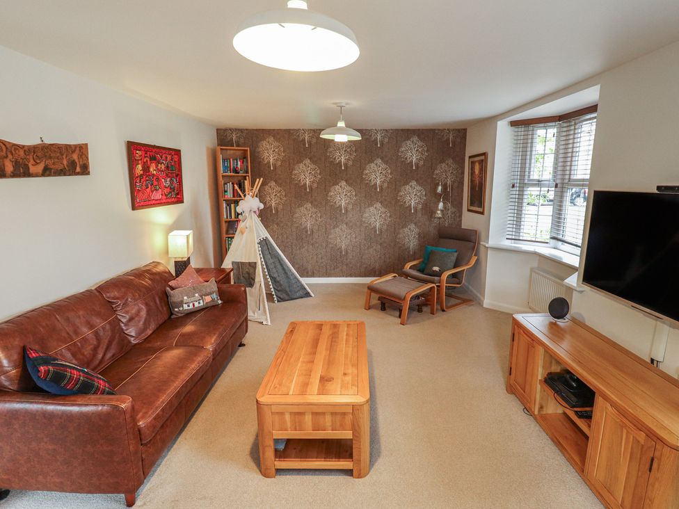 A living room with a brown sofa and wooden coffee table at 26 Otho Way
