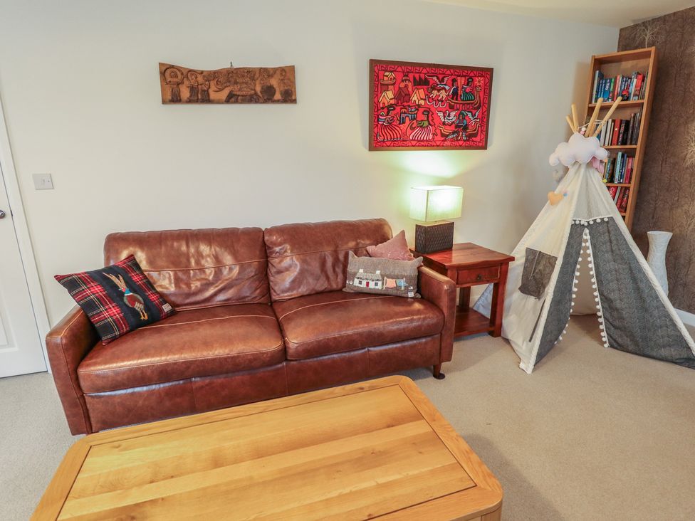 A living room with a sofa and decorative items at 26 Otho Way
