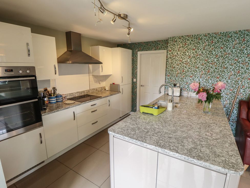 A kitchen with appliances and floral wallpaper at 26 Otho Way