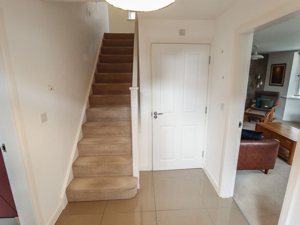 A hallway with stairs and a door at 26 Otho Way