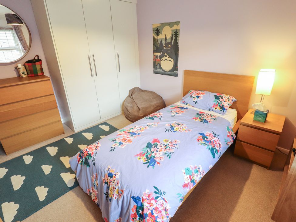 A bedroom with a bed, wardrobe, and bedside table at 26 Otho Way