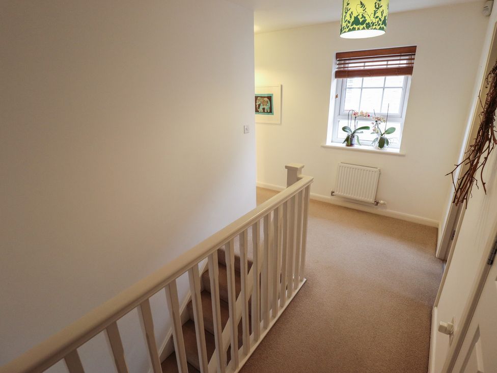 A hallway with a staircase and a window at 26 Otho Way