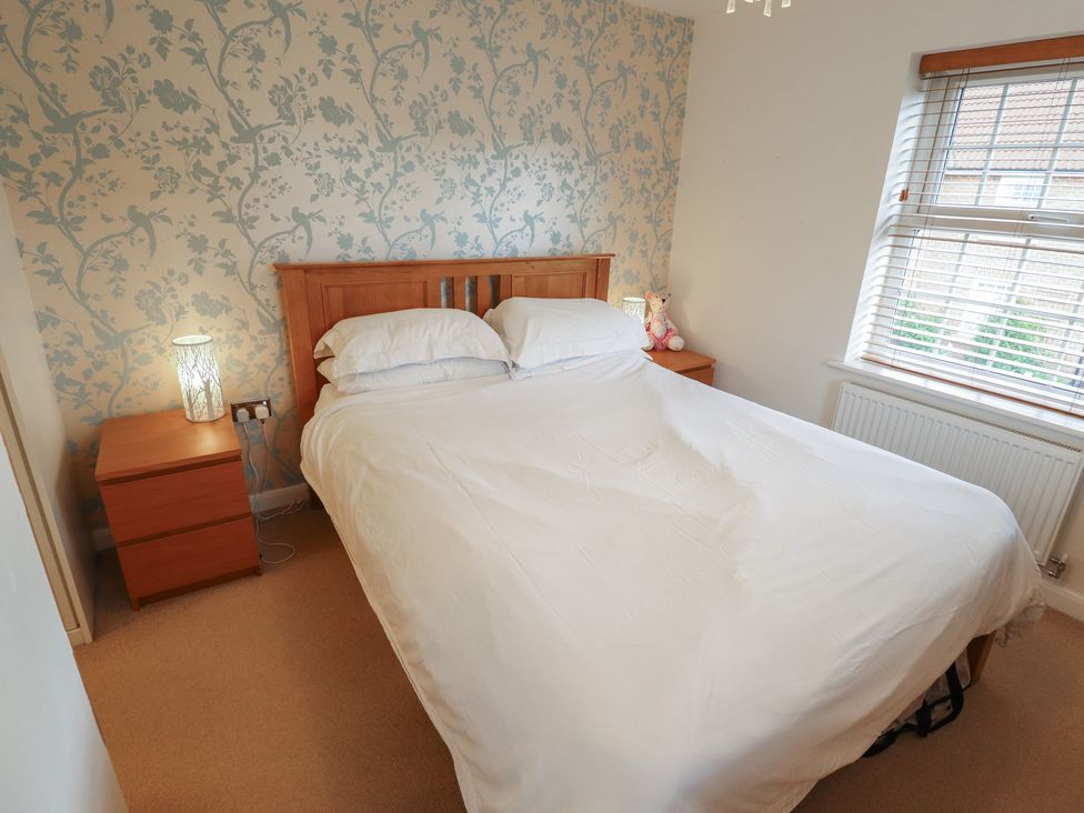 A bedroom with a bed and nightstand at 26 Otho Way