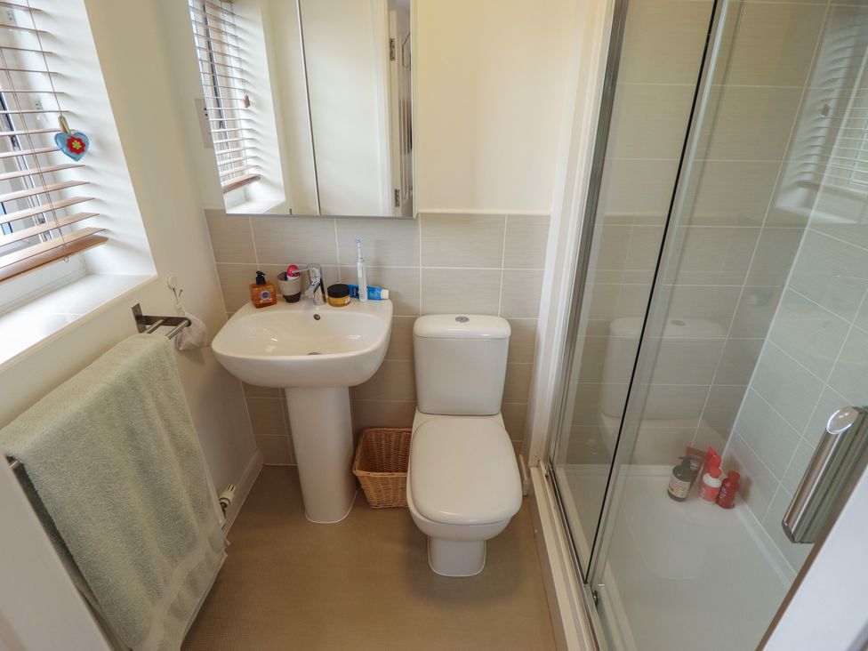 A bathroom with a sink, toilet, and shower at 26 Otho Way