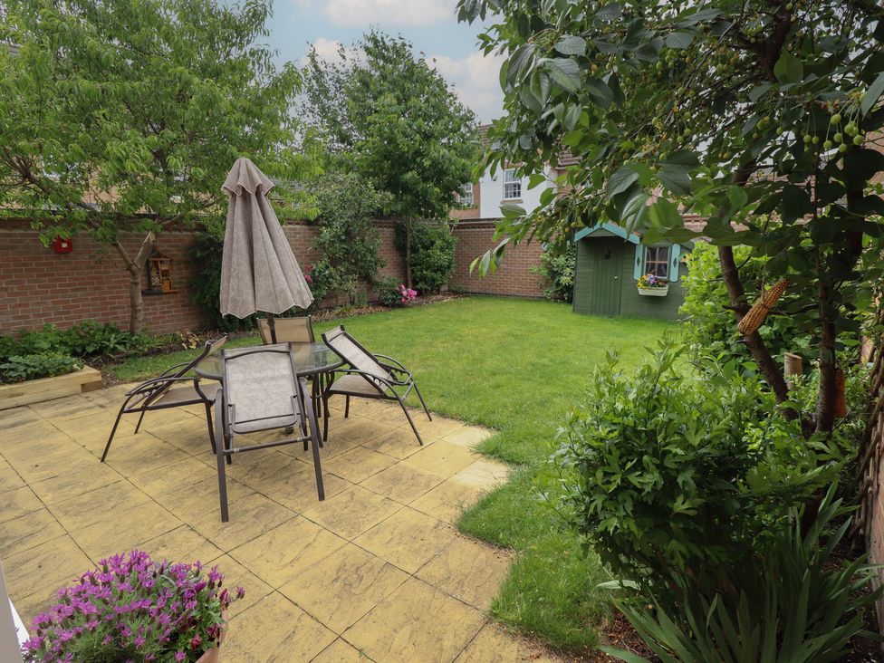 A garden with a table and chairs under an umbrella at 26 Otho Way 