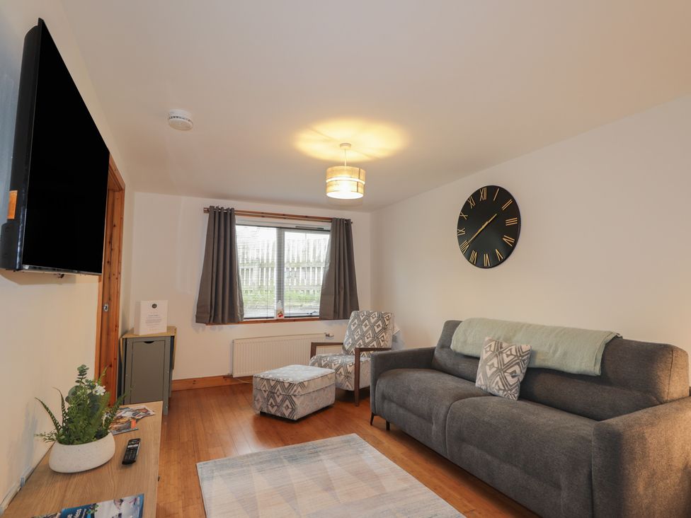 A living room with a sofa and television at 39 Knocknagael in Inverness