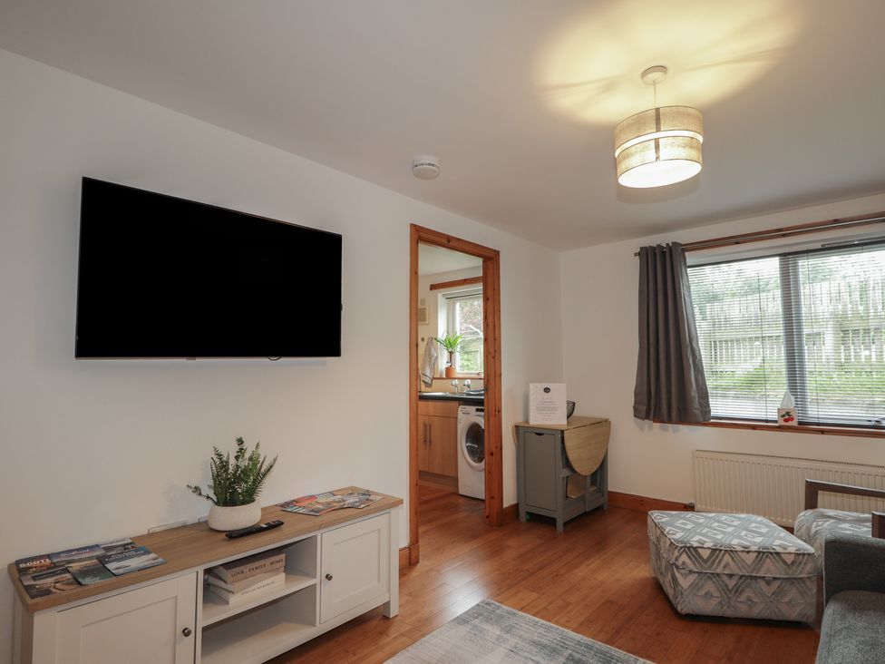 A living room with a television and coffee table at 39 Knocknagael in Inverness
