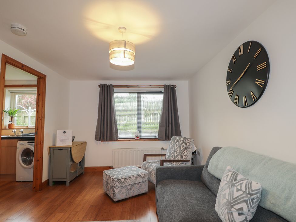 A living room with a sofa and armchair at 39 Knocknagael in Inverness