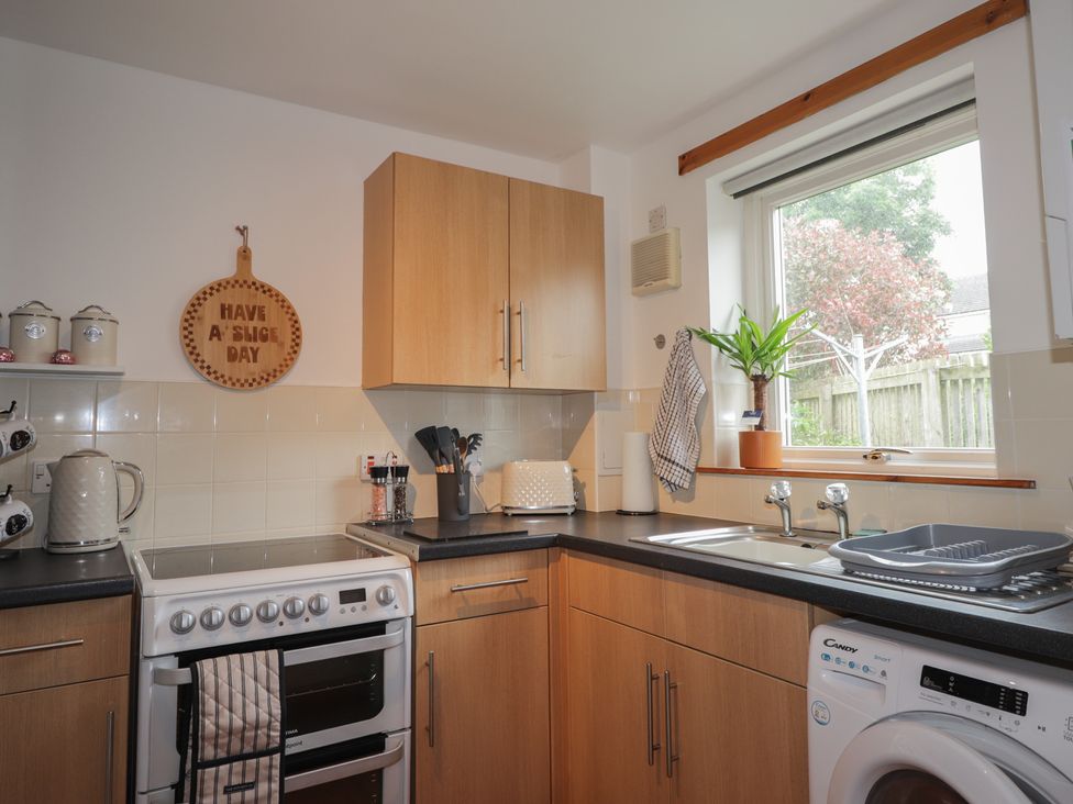 A kitchen with cabinets and appliances at 39 Knocknagael in Inverness