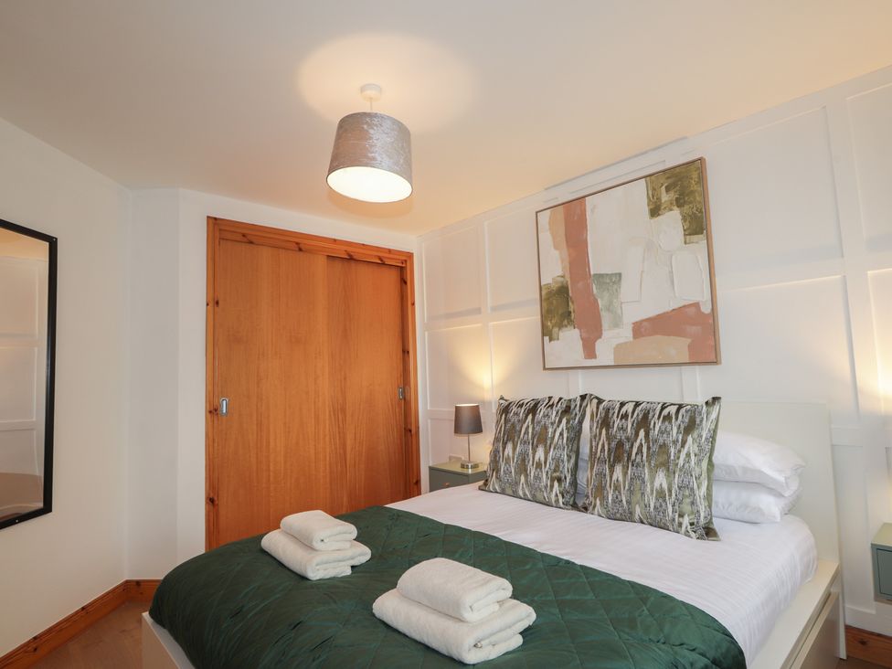 A bedroom with a bed and wardrobe at 39 Knocknagael in Inverness