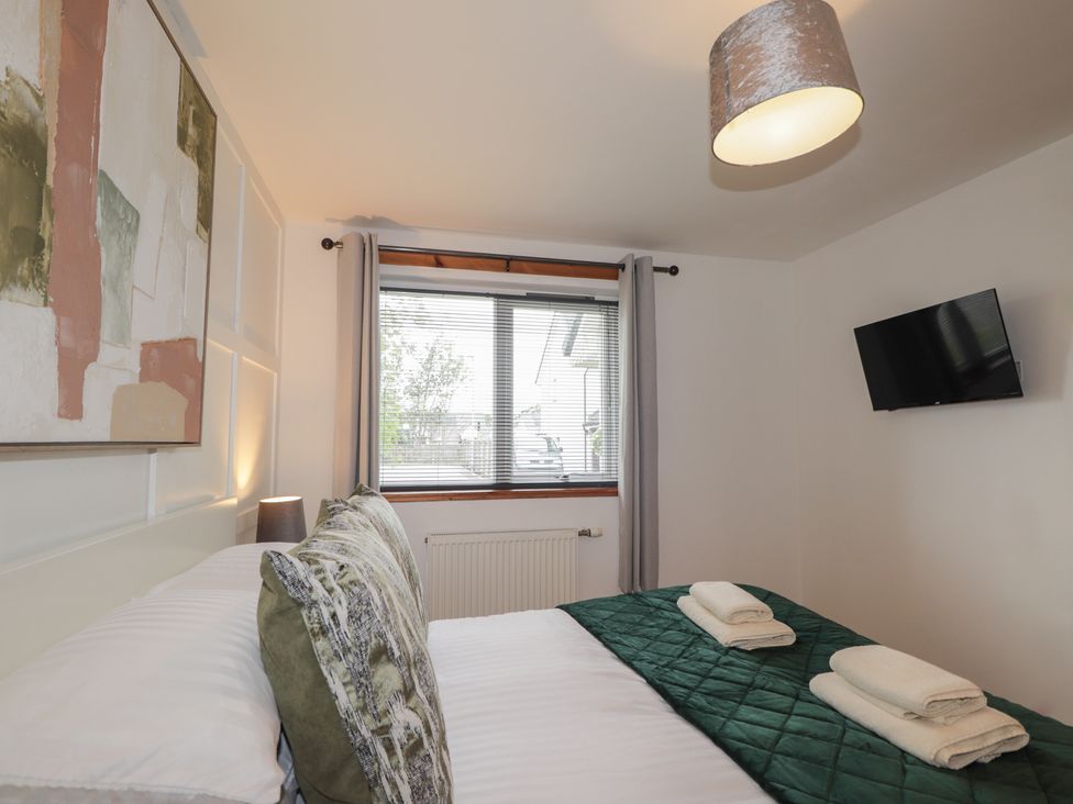 A bedroom with a bed and artwork on the wall at 39 Knocknagael in Inverness