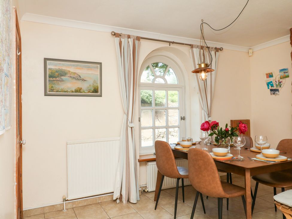 A dining room with a table and chairs at Gorway Cottage in Teignmouth