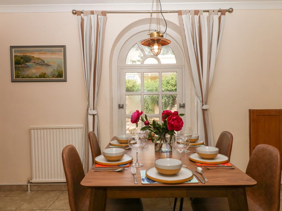 A dining room with a table set for a meal at Gorway Cottage Teignmouth