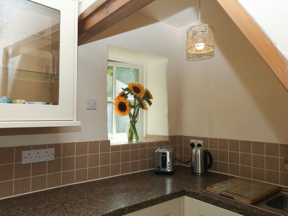A kitchen with flowers on the windowsill at Gorway Cottage in Teignmouth