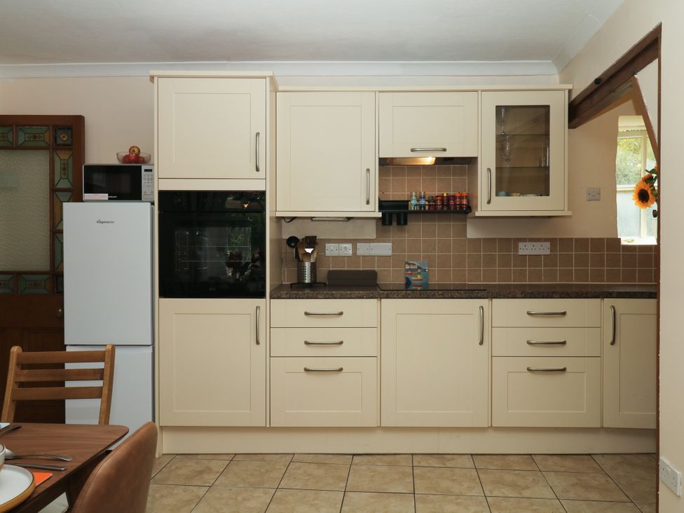 A kitchen with appliances and cabinets at Gorway Cottage in Teignmouth