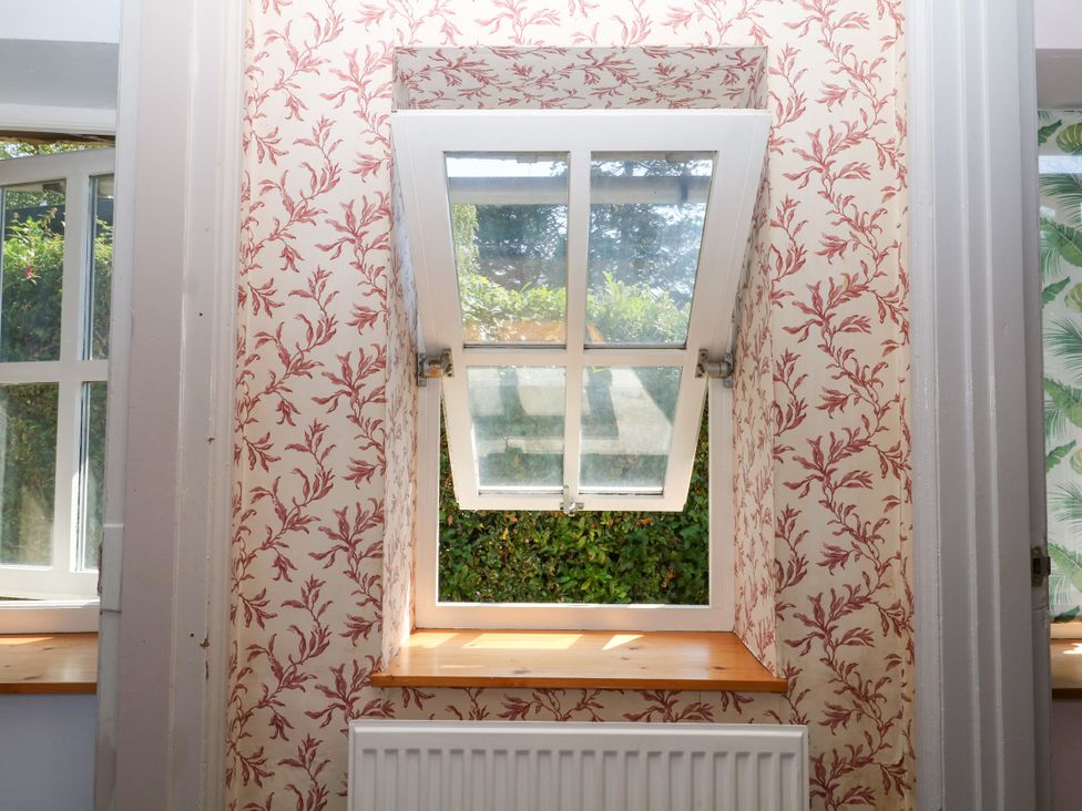 A window with an open top section and a radiator at Gorway Cottage in Teignmouth