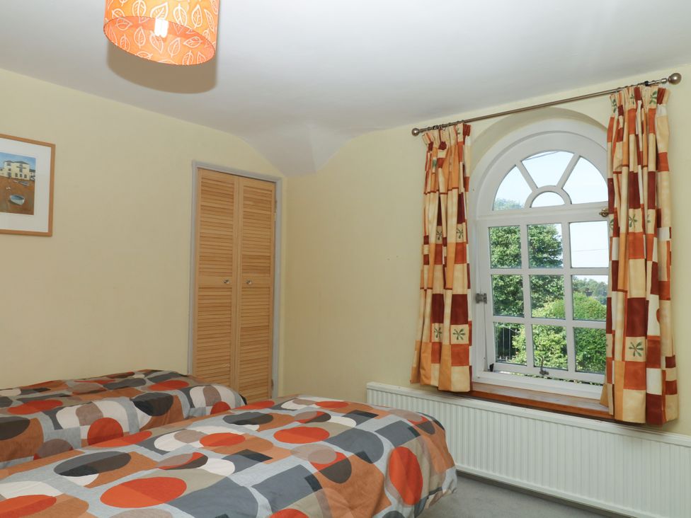 A bedroom with two beds and a window at Gorway Cottage in Teignmouth