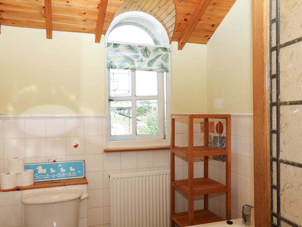 A bathroom with a toilet and window at Gorway Cottage in Teignmouth