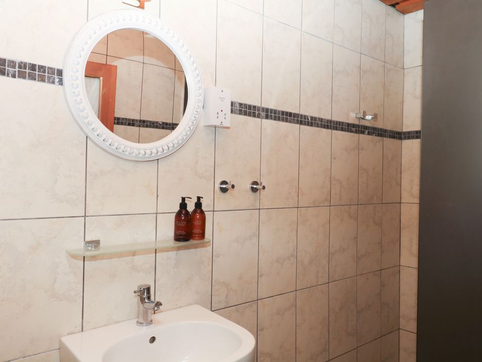 A bathroom with a sink and mirror at Gorway Cottage Teignmouth