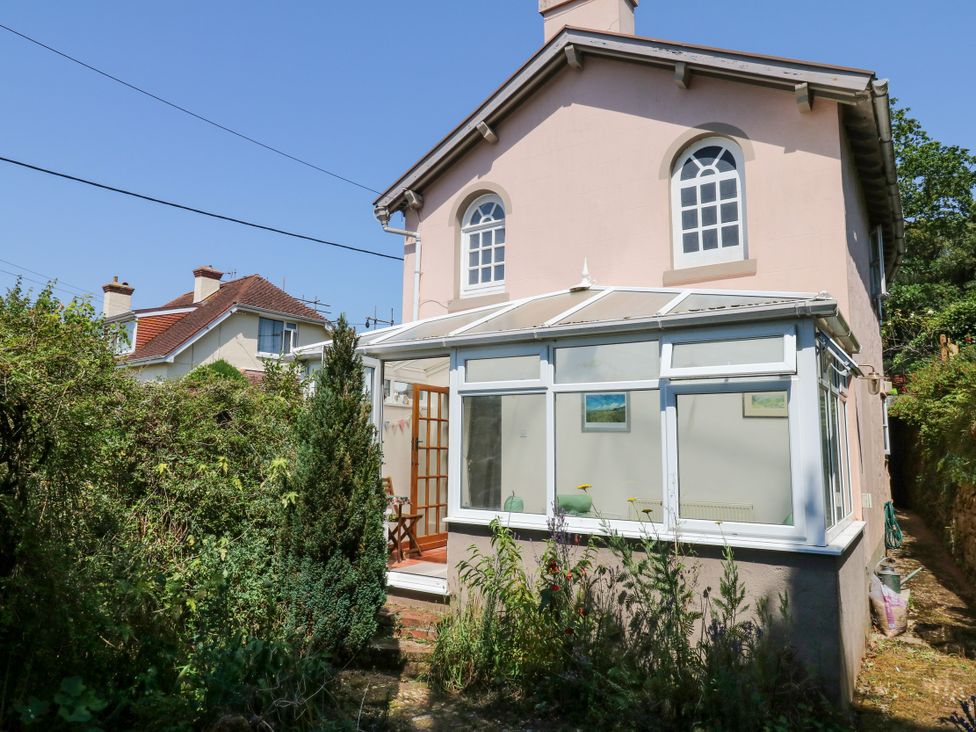 A house with a conservatory and garden at Gorway Cottage in Teignmouth