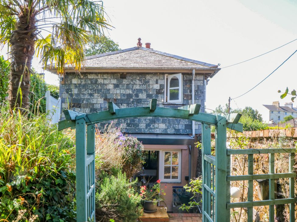 A house with a garden gate and palm tree at Gorway Cottage in Teignmouth