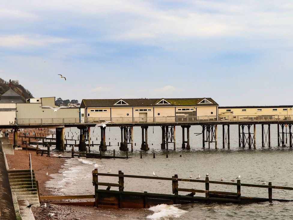 A pier with buildings above water in Teignmouth at Gorway Cottage