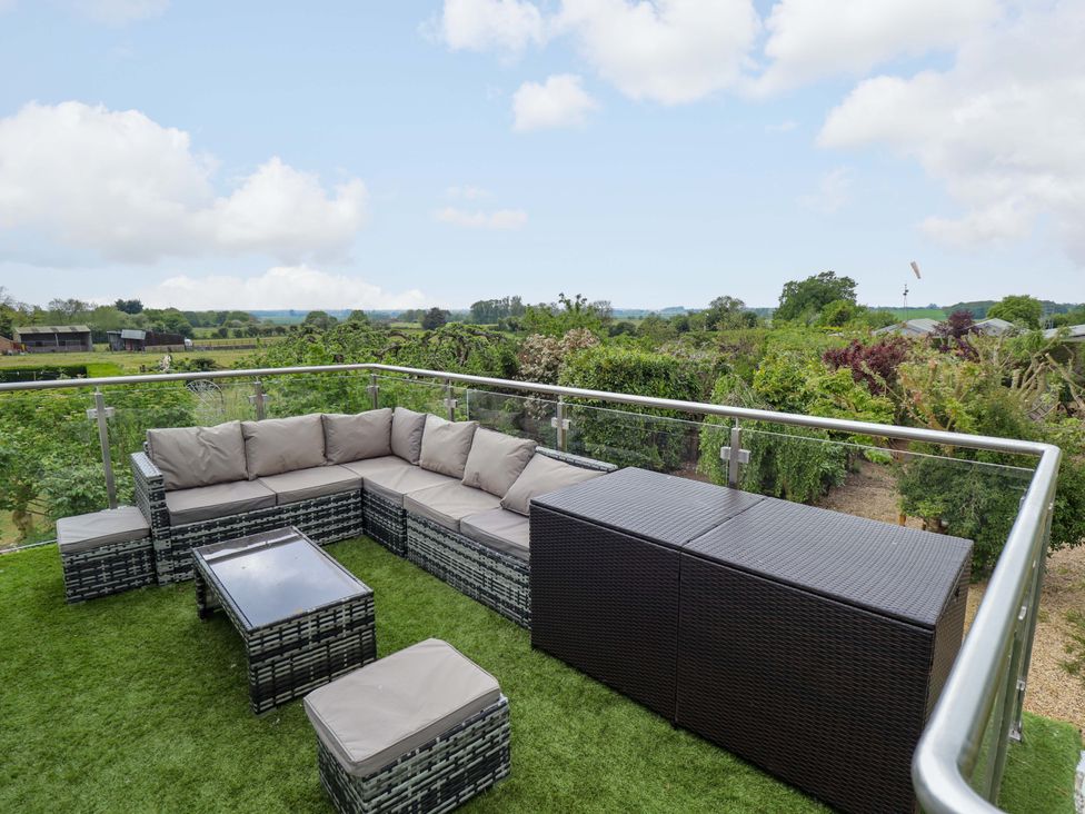 An outdoor seating area with a lounge chair and table at The Hen House 