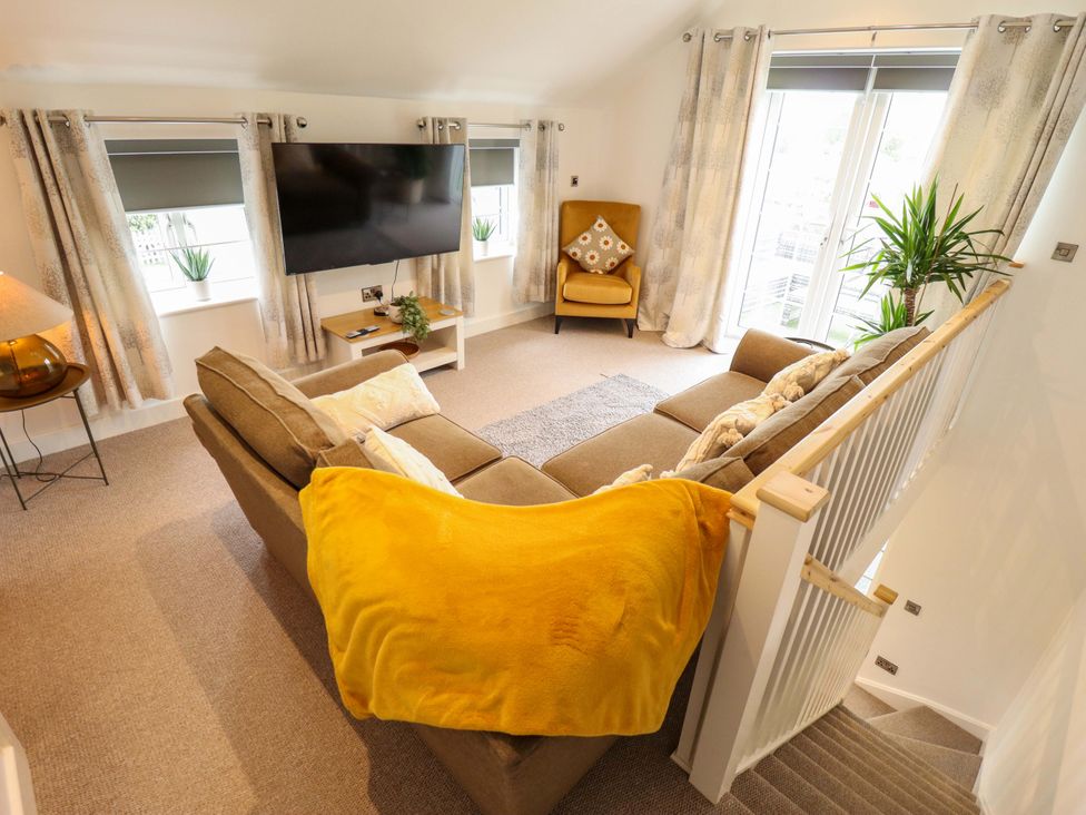 A living room with a sofa and TV at The Hen House