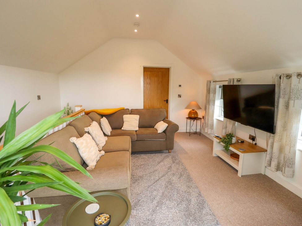 A snug with a sofa and television at The Hen House