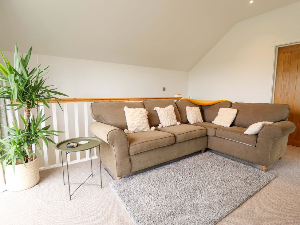 A living room with a sofa and plant at The Hen House 