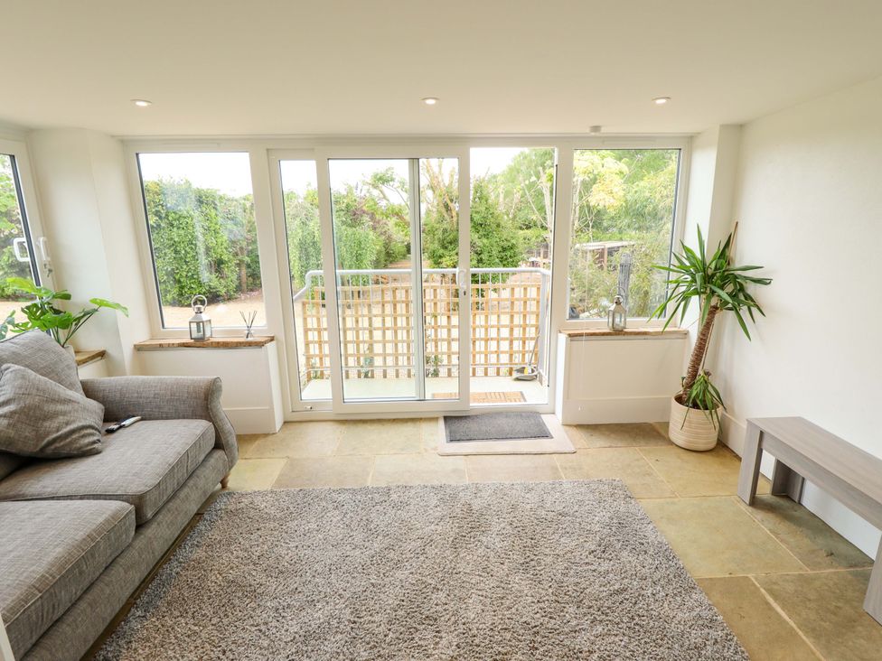 A snug with a sofa and view of garden at The Hen House 