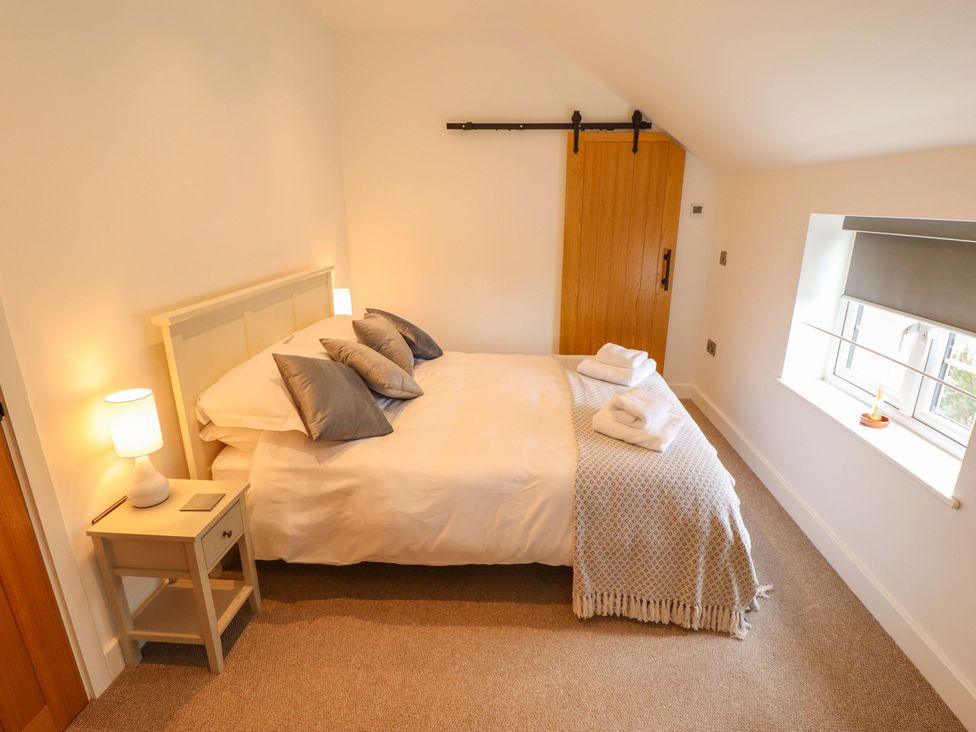 A bedroom with a bed and bedside table at The Hen House