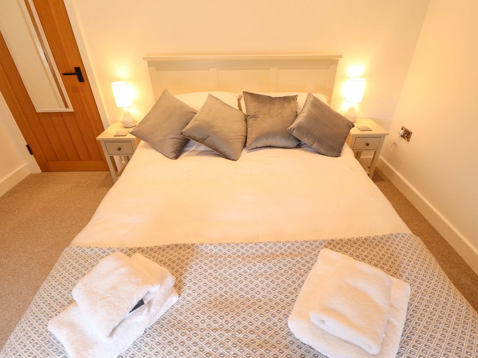 A bedroom with a bed and bedside tables at The Hen House 