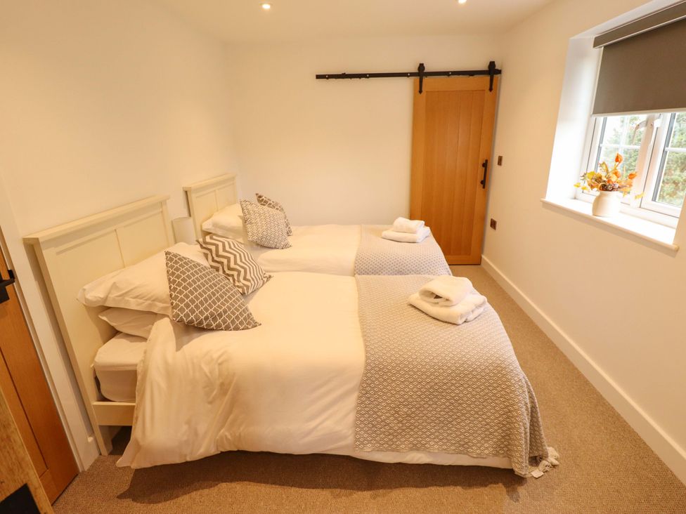 A bedroom with twin beds and a window at The Hen House in 