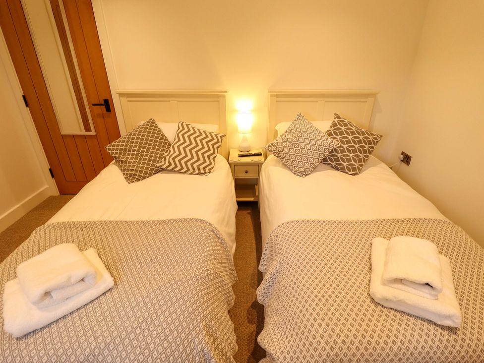 A bedroom with two beds and a nightstand at The Hen House